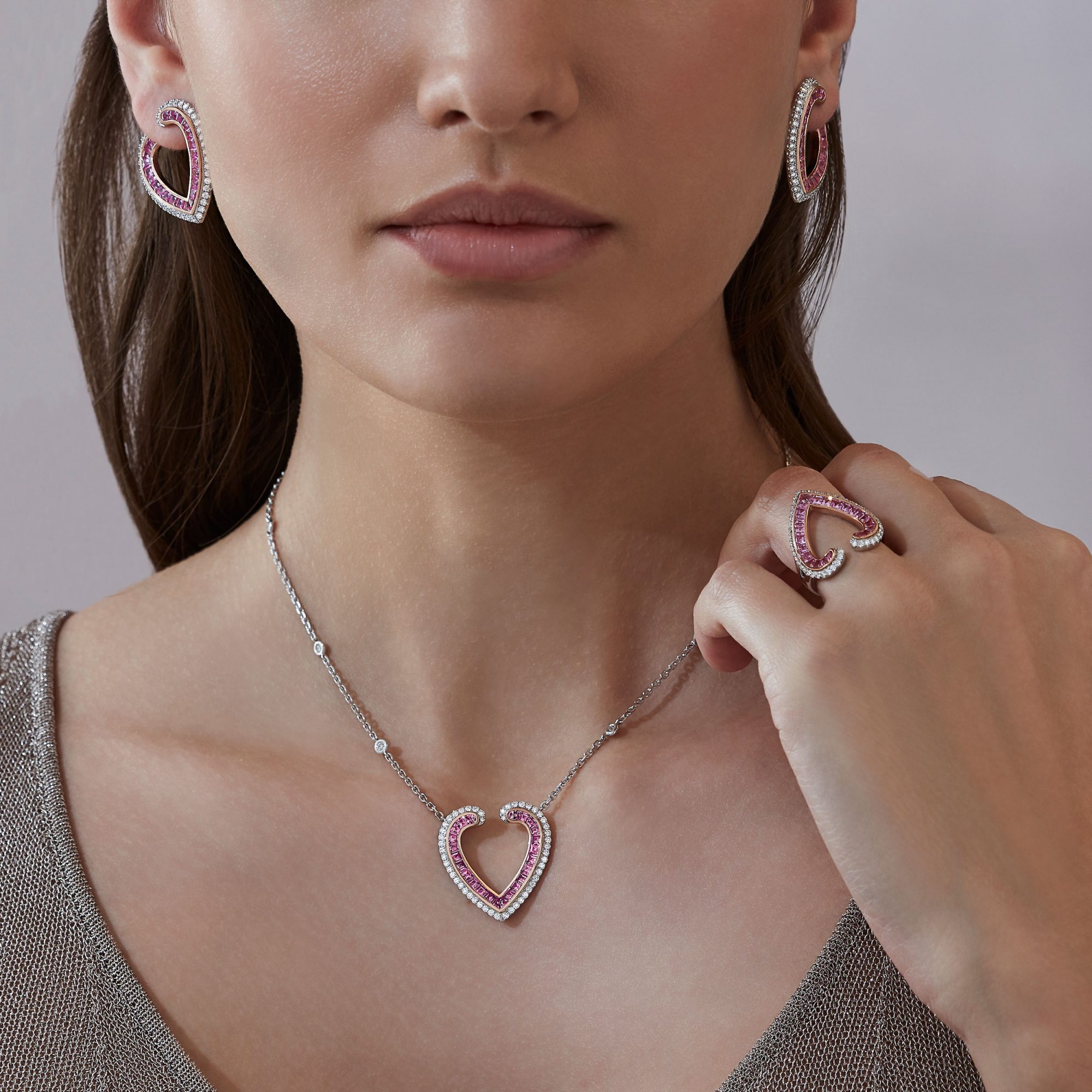 Model wears Garrard Aloria jewellery collection pink sapphire and diamond pendant earrings and ring