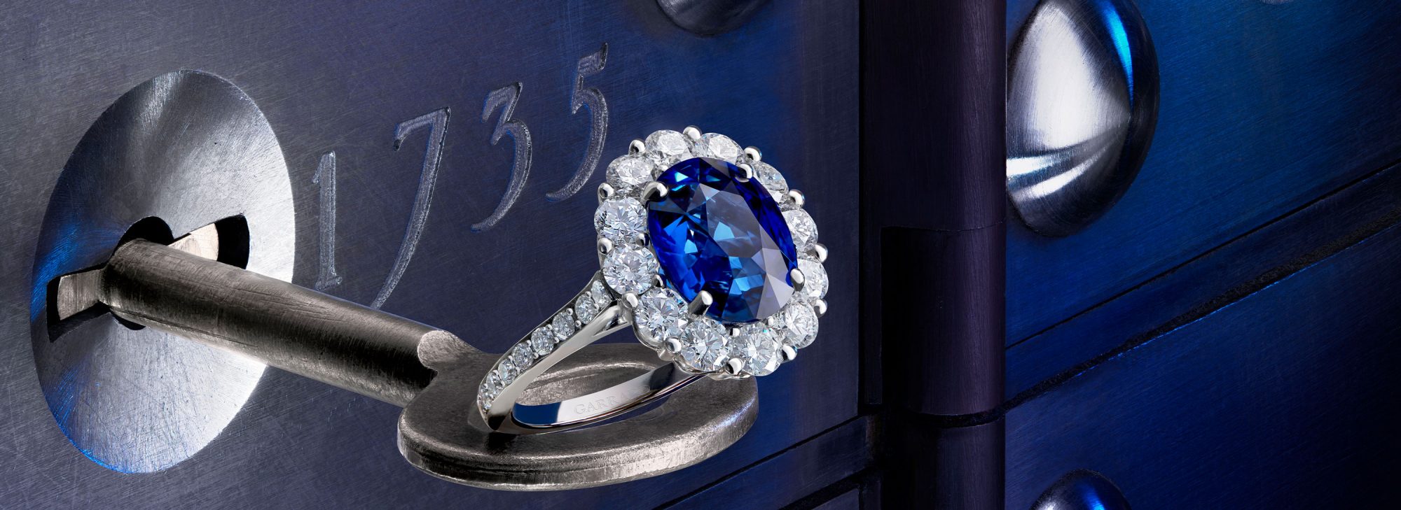 The Garrard Jewelled Vault 5.05ct Oval Royal Blue Sapphire and Diamond Cluster Ring In Platinum