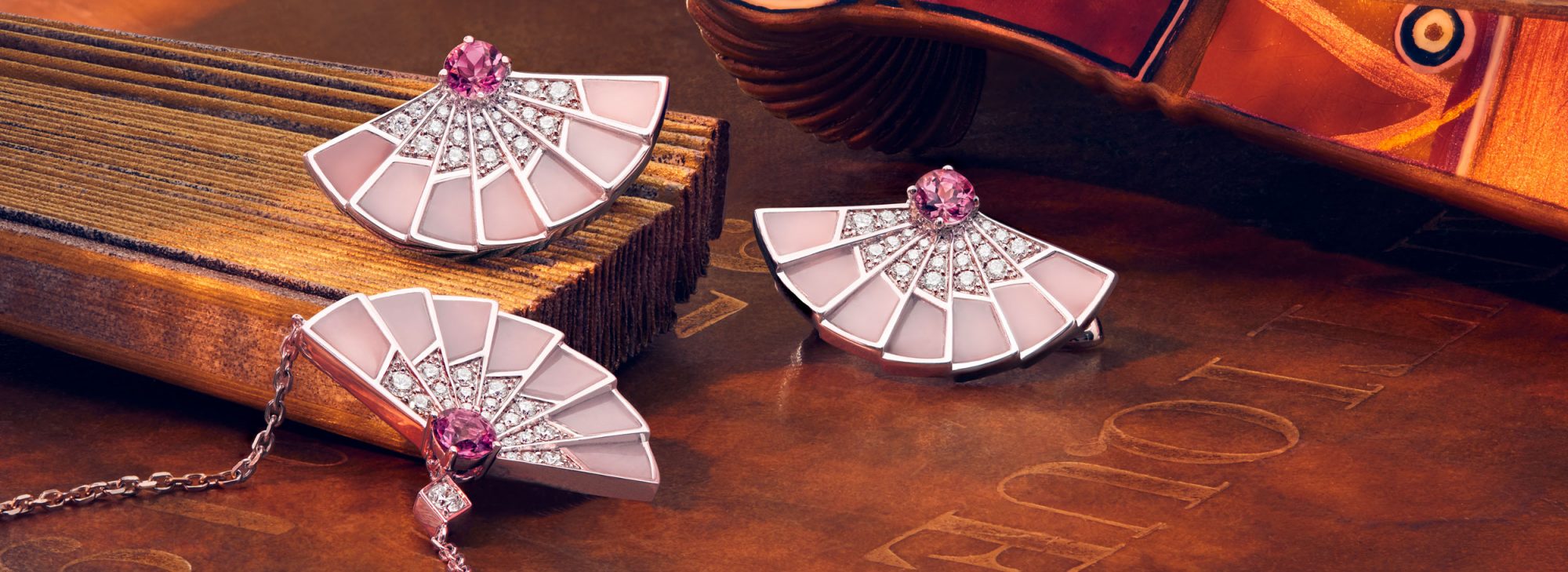 Close up of the Garrard Fanfare Symphony jewellery collection mother of pear and diamond earrings and pendant