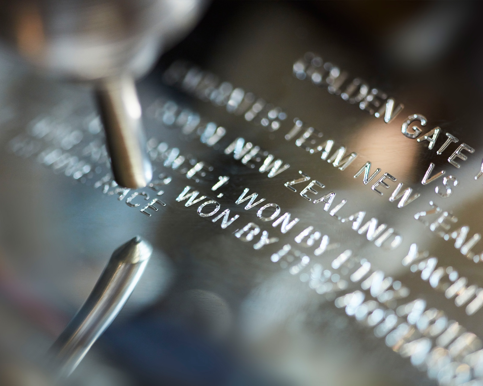 a Garrard craftsman engraving the winning team name on the silver Americas Cup desktop 1