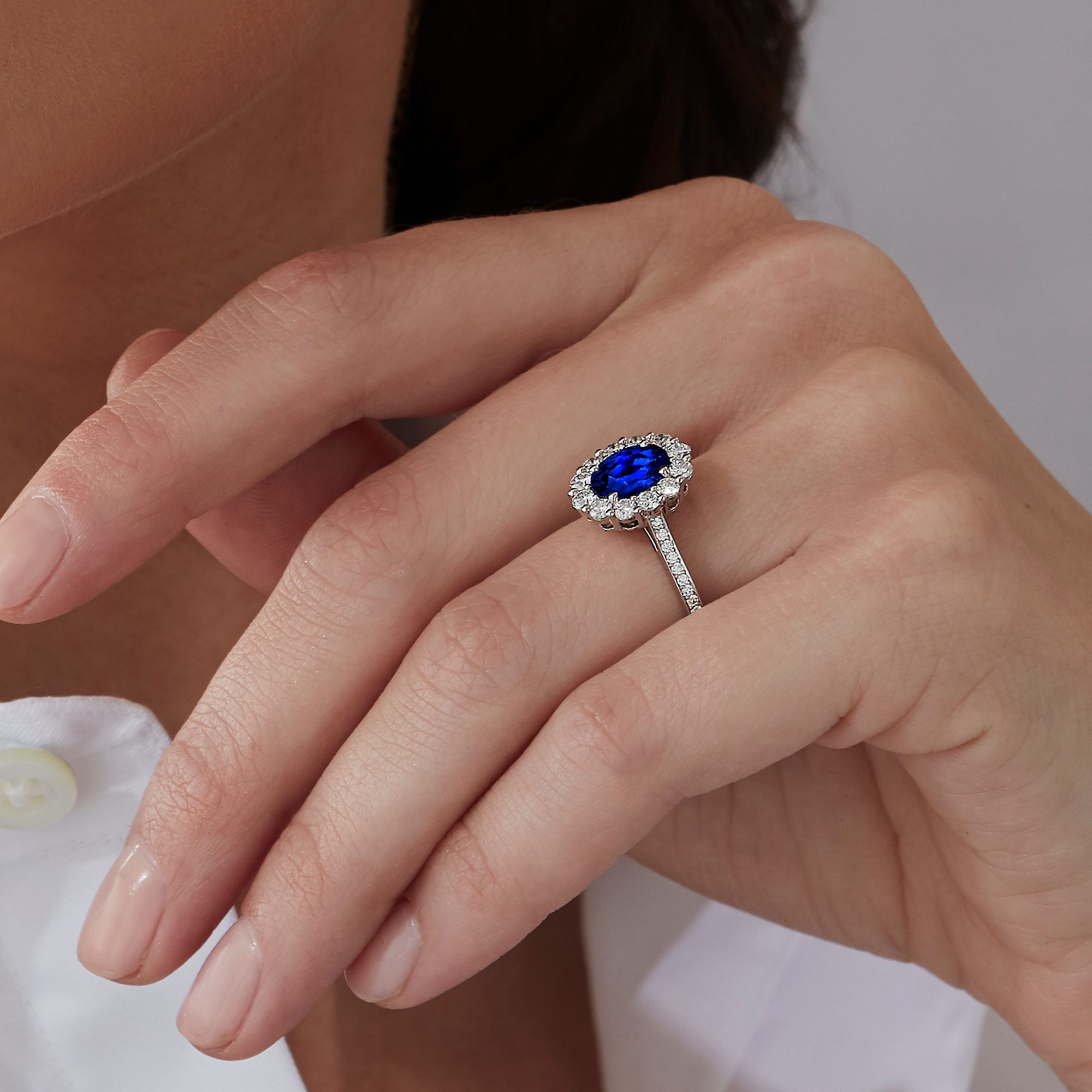 Close up of a model wearing a Garrard Bridal Collection 1735 oval Sapphire and diamond engagement ring