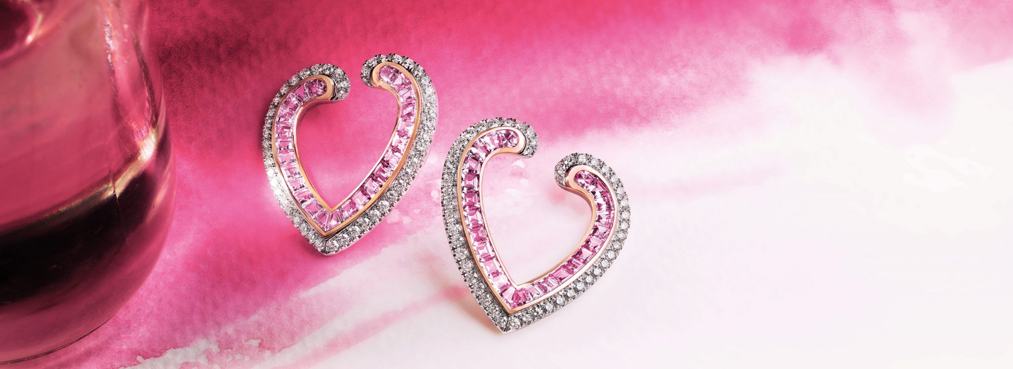 Close up of a pair of Aloria Calibre Cut Pink Sapphire Earrings In 18ct White and Rose Gold with Diamonds from Garrard