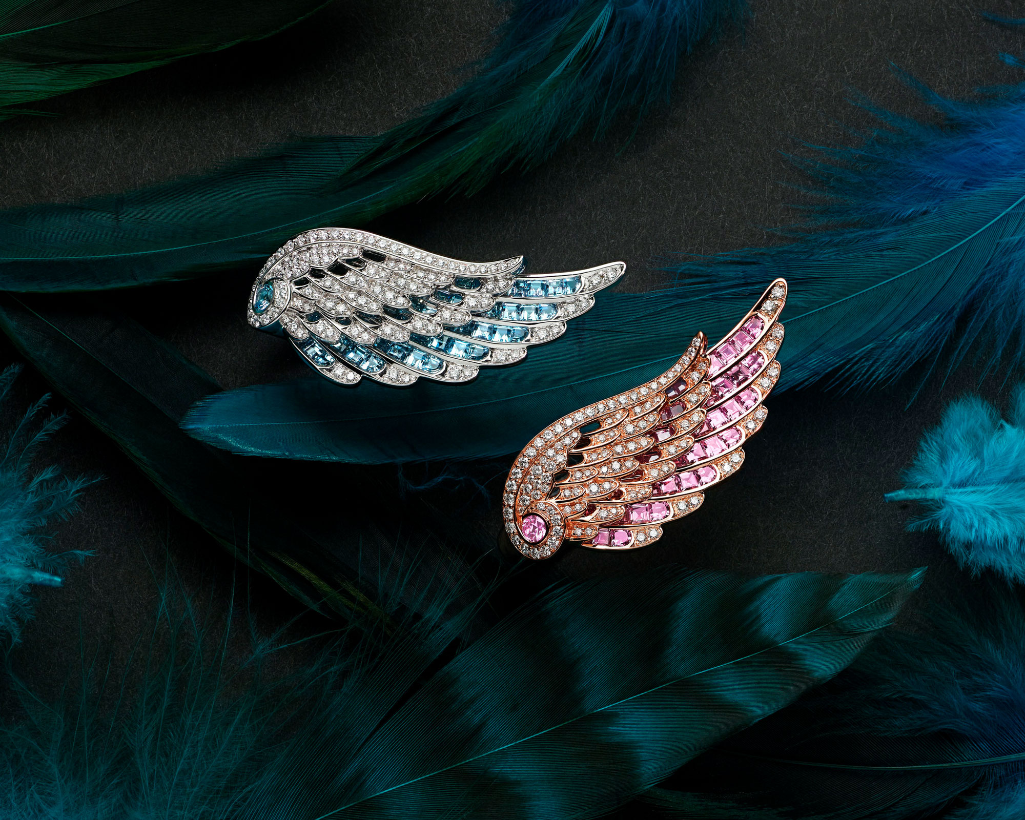 Close up of two Wings Embrace Across the Finger Diamond Ring set with Aquamarine and Pink Sapphire on feathers mobile