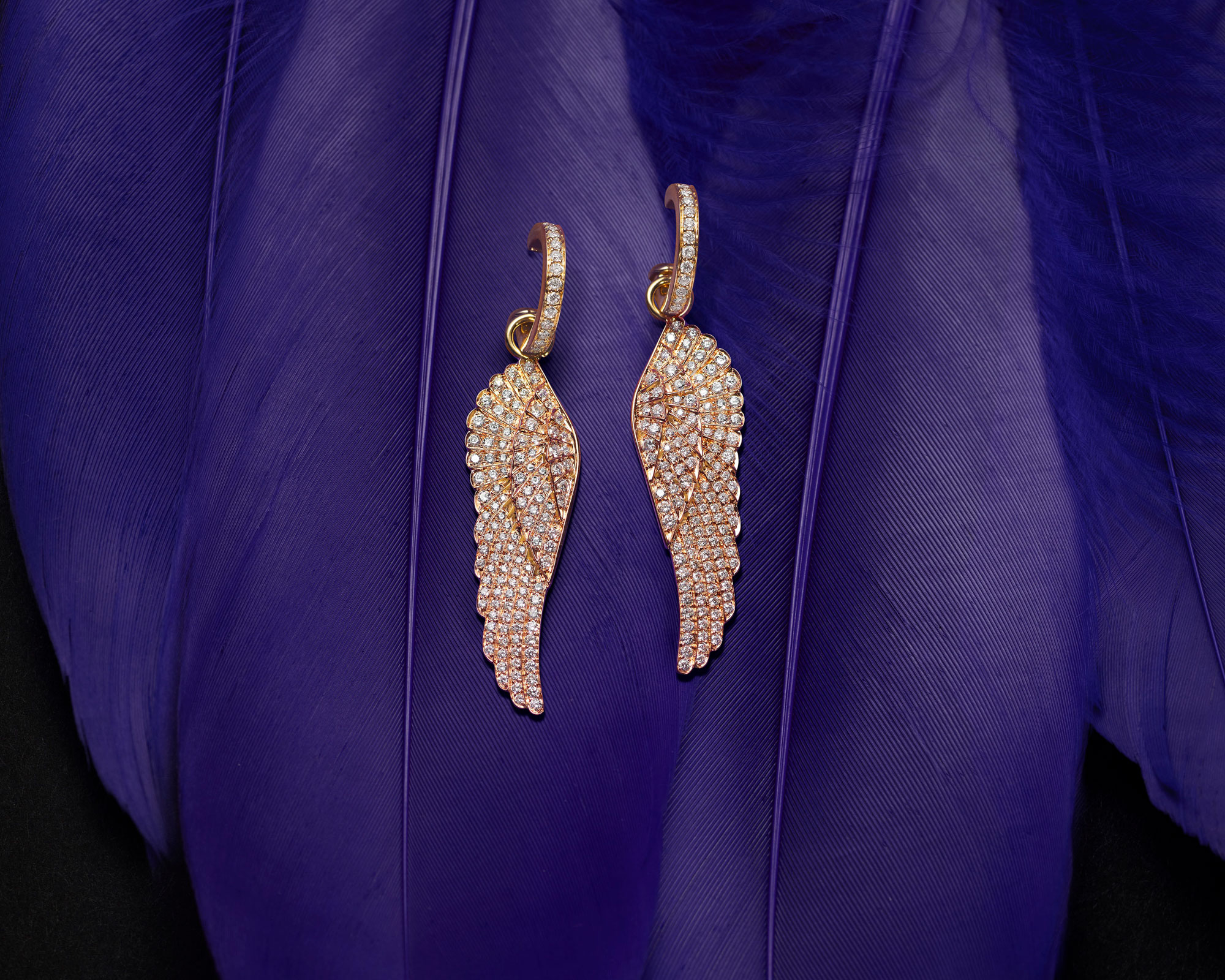a pair of Garrard Wings Classic jewellery collection Hoop and Drop Diamond Earrings on feathers 1