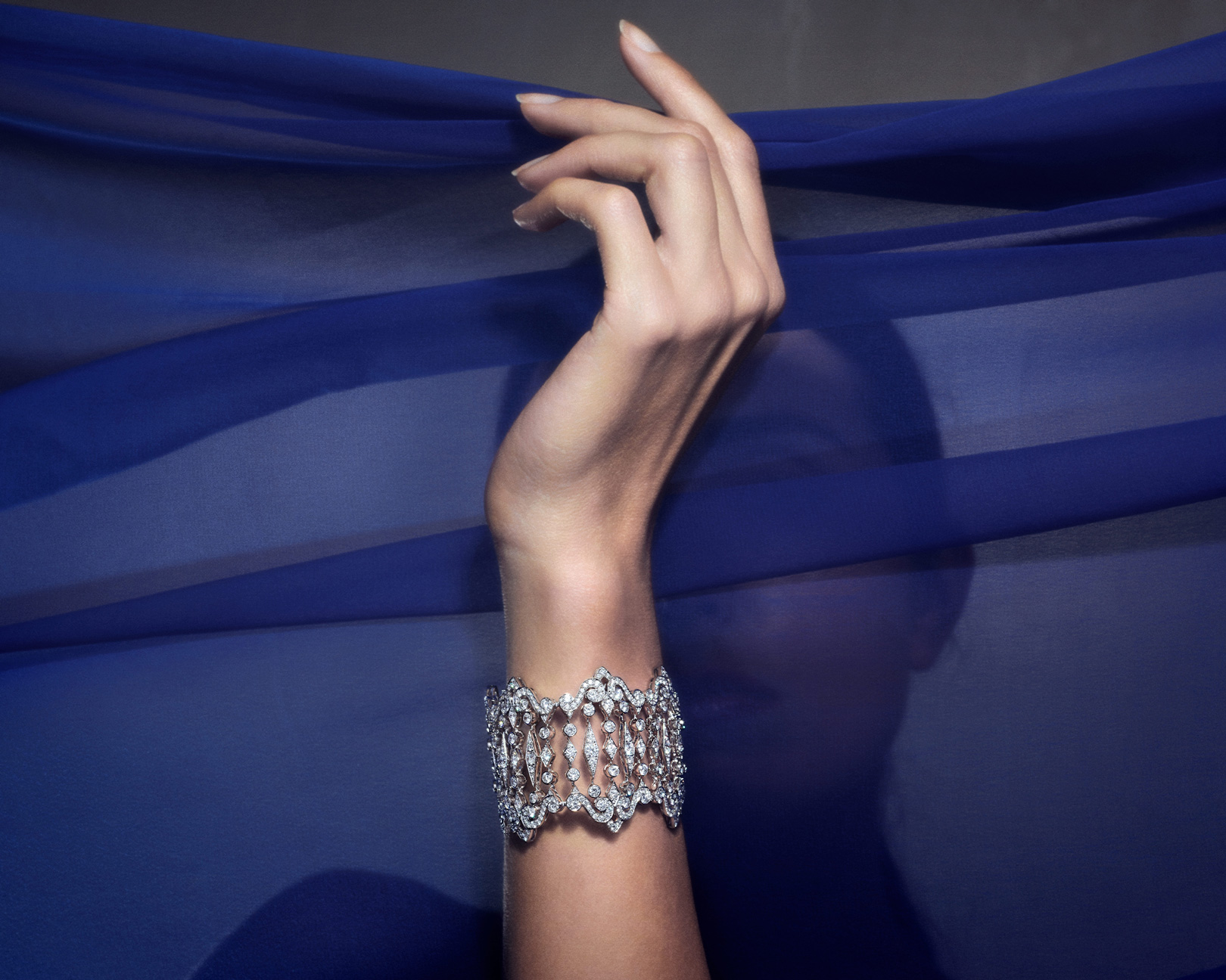 a woman wearing three Garrard Albemarle jewellery collection diamonds bangel