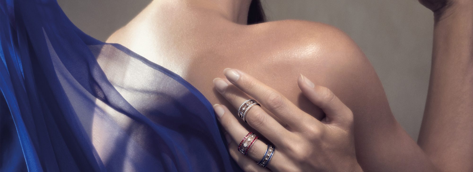 a woman wearing three Garrard Albemarle jewellery collection rings set in diamonds rubies and sapphires